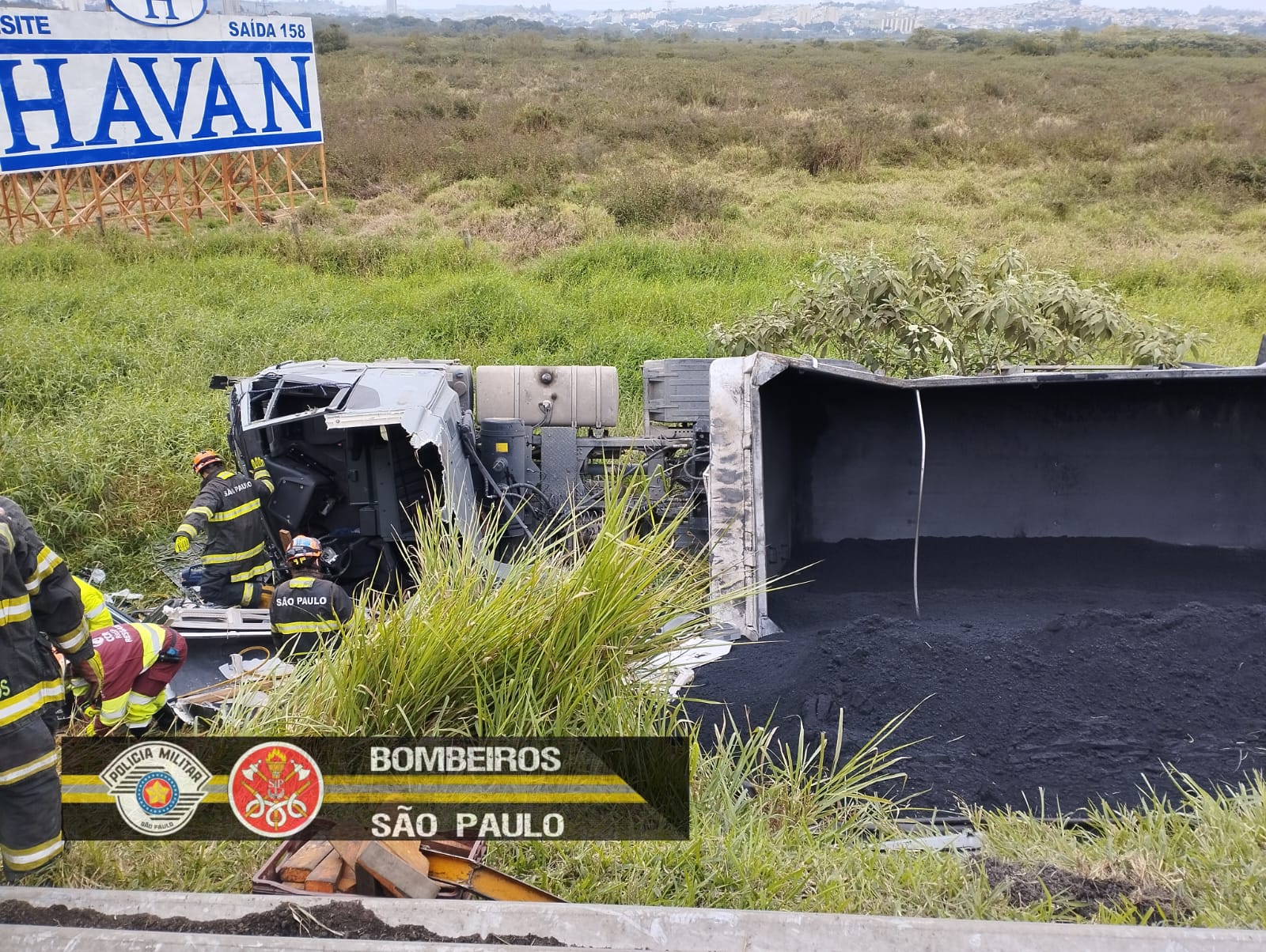 Motorista fica preso nas ferragens de caminhão, que saiu da pista e capotou na Via Dutra em Jacareí