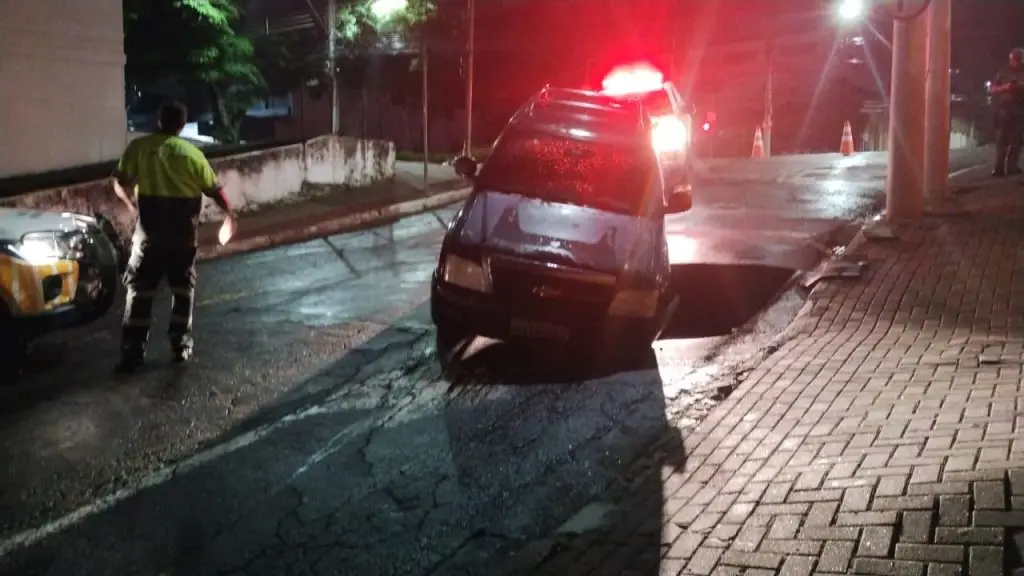 Carro cai em buraco após rompimento de tubulação da Sabesp em São José dos Campos